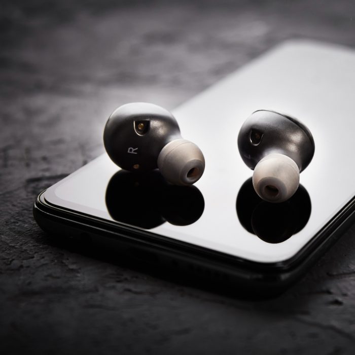 Wireless earphones on a smartphone. Bluetooth headphones for listen audio